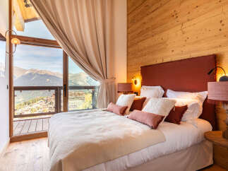 Experience luxury living in this stunning bedroom with breathtaking mountain views.