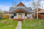 Charming two-story home with a welcoming front porch and a beautifully landscaped yard.