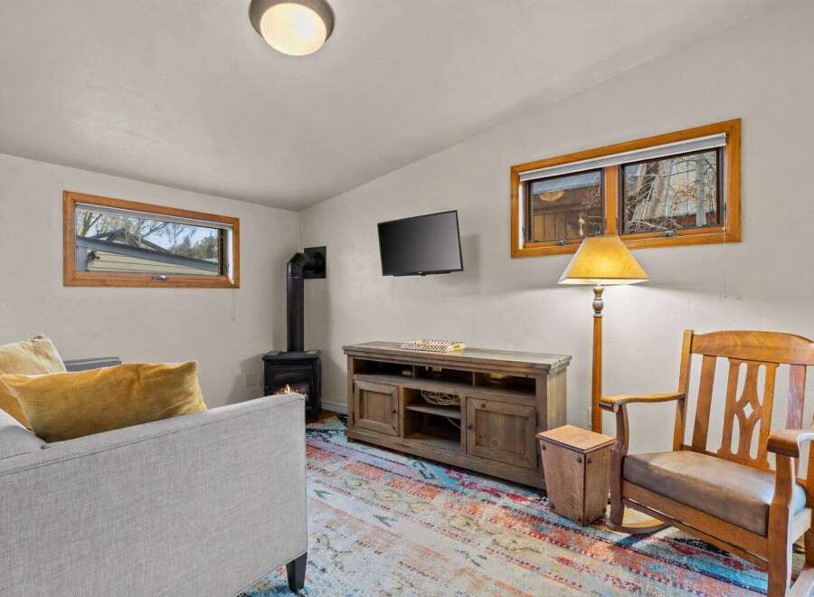 Cozy up in this charming living room featuring a wood-burning stove, perfect for those chilly evenings.
