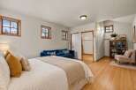 This inviting bedroom boasts a cozy ambiance with its plush bed, complemented by a stylish blue sofa.