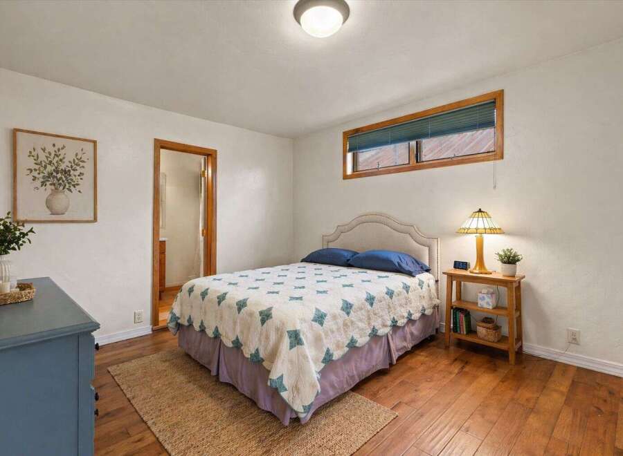 This charming bedroom features a cozy bed with a unique quilt and a stylish headboard.