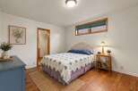 This charming bedroom features a cozy bed with a unique quilt and a stylish headboard.