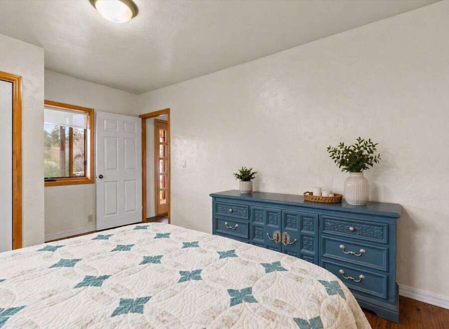 This charming bedroom features a beautiful blue dresser, adding a pop of color to the space.