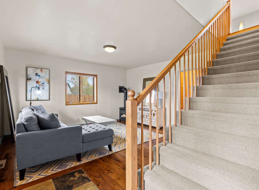 Step into this inviting home featuring a cozy living area and a charming staircase.