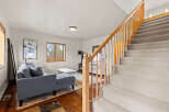 Step into this inviting home featuring a cozy living area and a charming staircase.