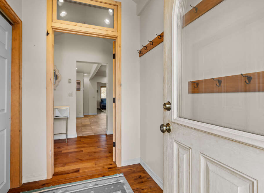 Step into this inviting entryway, showcasing beautiful hardwood floors and a glimpse of the home's interior.