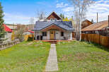 Charming cottage-style home with a welcoming front porch and a beautiful wooden walkway.