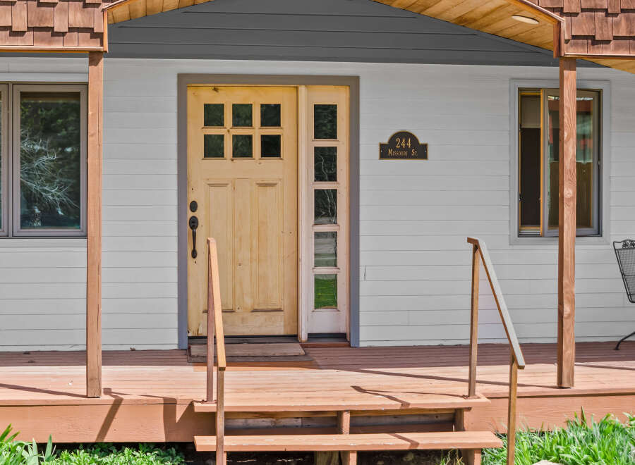 Charming home with a welcoming front porch and a beautiful wooden door.