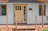 Charming home with a welcoming front porch and a beautiful wooden door.