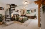 This cozy bedroom features a unique spiral staircase leading to an upper level, adding a touch of architectural interest.