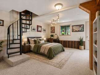 This cozy bedroom features a unique spiral staircase leading to an upper level, adding a touch of architectural interest.