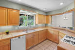 Step into this inviting kitchen, featuring warm wooden cabinetry and ample counter space.