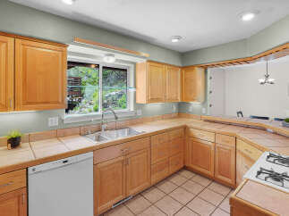 Step into this inviting kitchen, featuring warm wooden cabinetry and ample counter space.