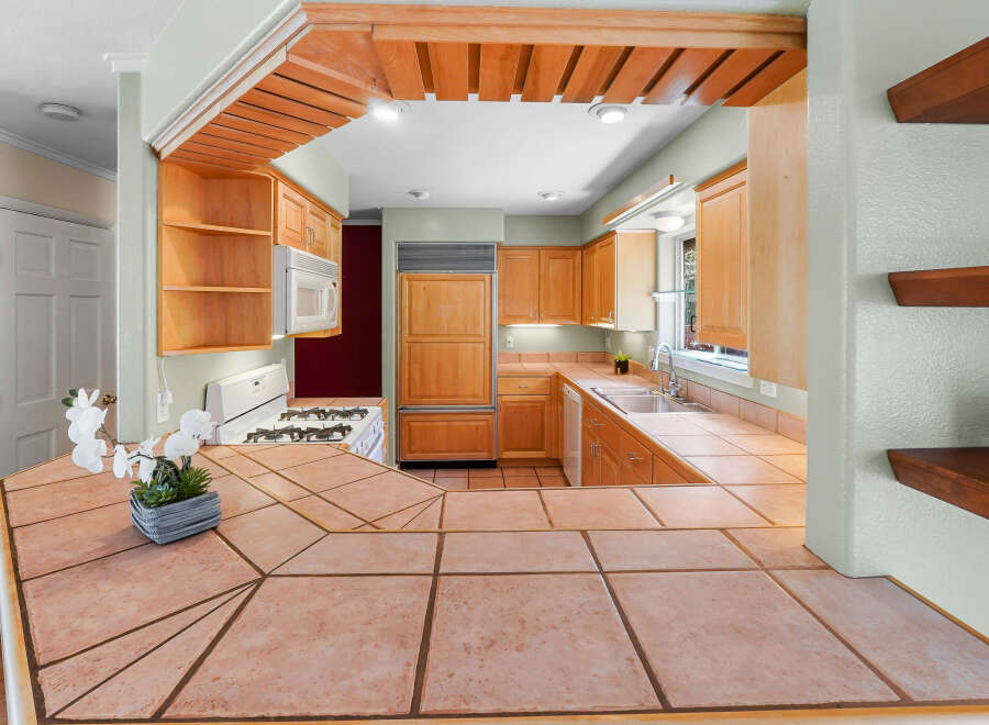 Step into this inviting kitchen, featuring warm wood cabinetry and a stylish tile countertop.