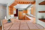 Step into this inviting kitchen, featuring warm wood cabinetry and a stylish tile countertop.