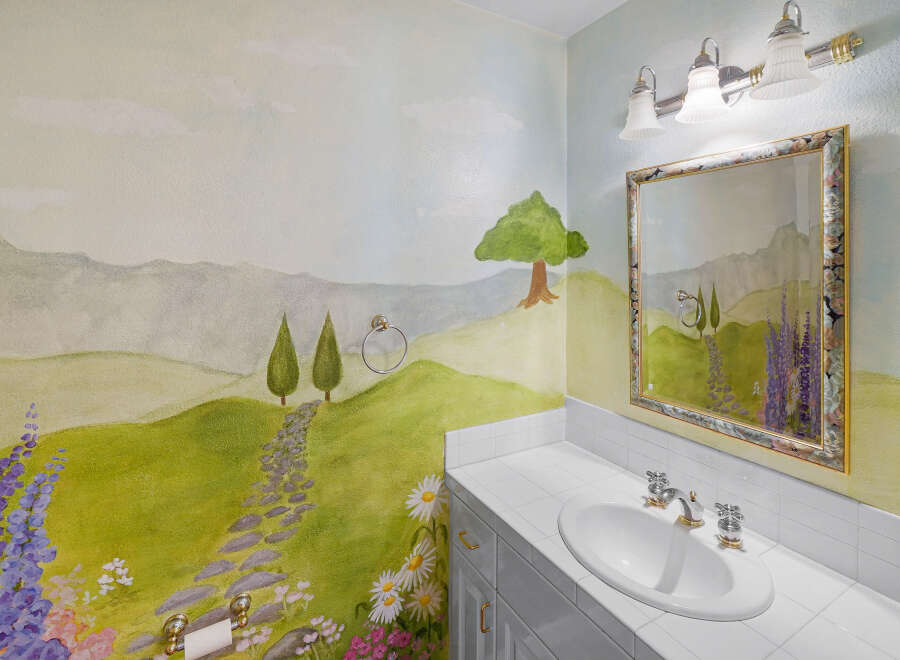 This charming bathroom features a whimsical mural, creating a serene and artistic atmosphere.