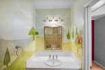 Step into a whimsical powder room with enchanting hand-painted murals.