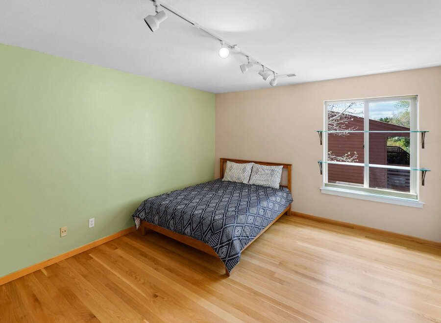 This inviting bedroom features a cozy bed with a stylish patterned duvet and pillows, perfect for a relaxing retreat.