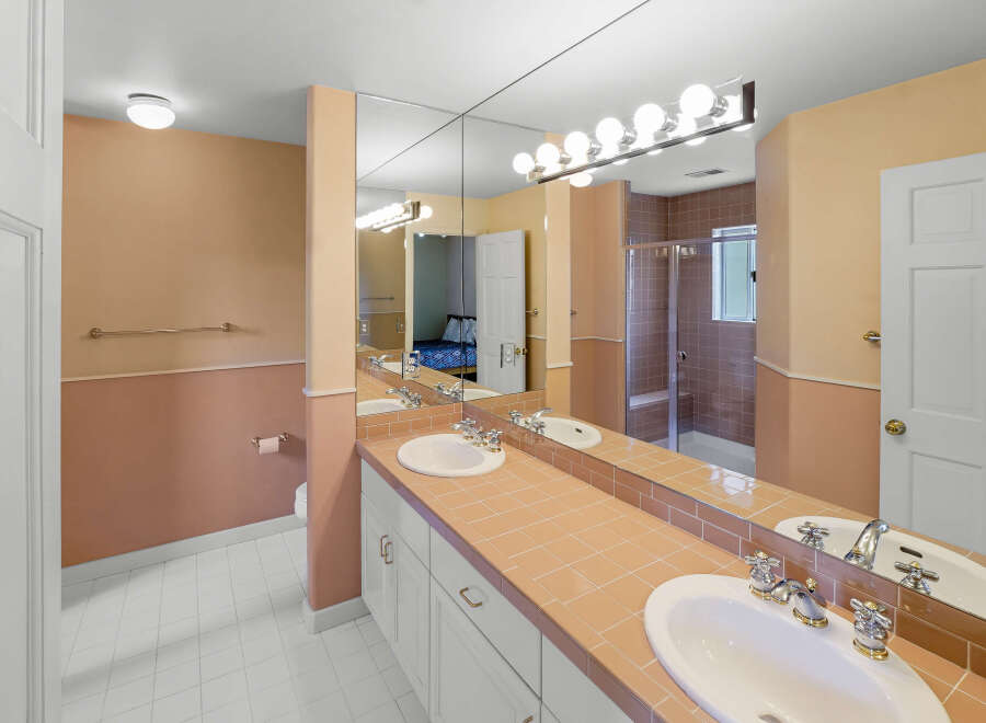 This bathroom features a double vanity with ample counter space, perfect for getting ready in the morning.