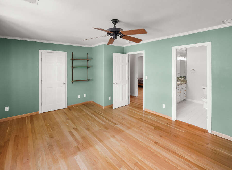 Step into this inviting bedroom, featuring beautiful hardwood floors and a fresh, modern aesthetic.