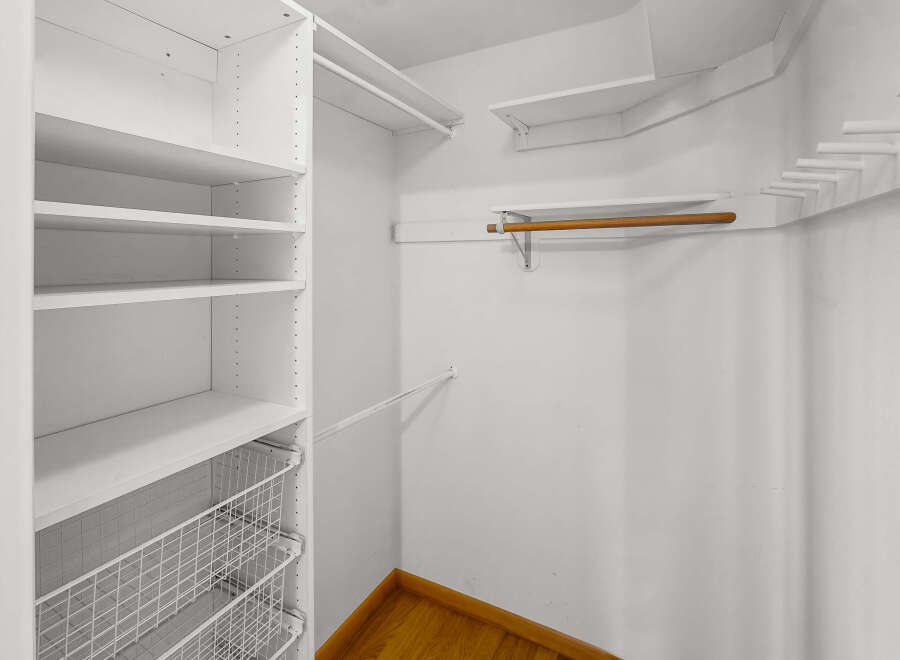 Step into this well-organized walk-in closet, offering ample storage space for your wardrobe.