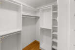 Step into this spacious walk-in closet, offering ample storage with its custom shelving and hanging rods.