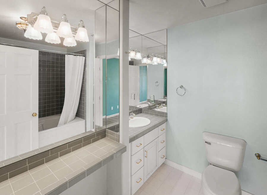 This bathroom features a sleek design with a combination of white and gray tiles.