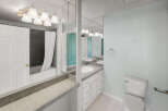 This bathroom features a sleek design with a combination of white and gray tiles.