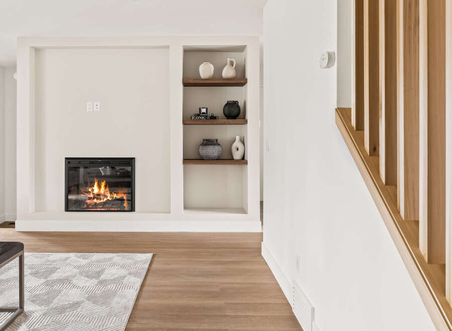 Experience the warmth of this inviting living space, featuring a cozy fireplace and stylish built-in shelving.