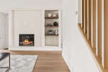 Experience the warmth of this inviting living space, featuring a cozy fireplace and stylish built-in shelving.