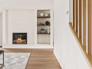Experience the warmth of this inviting living space, featuring a cozy fireplace and stylish built-in shelving.