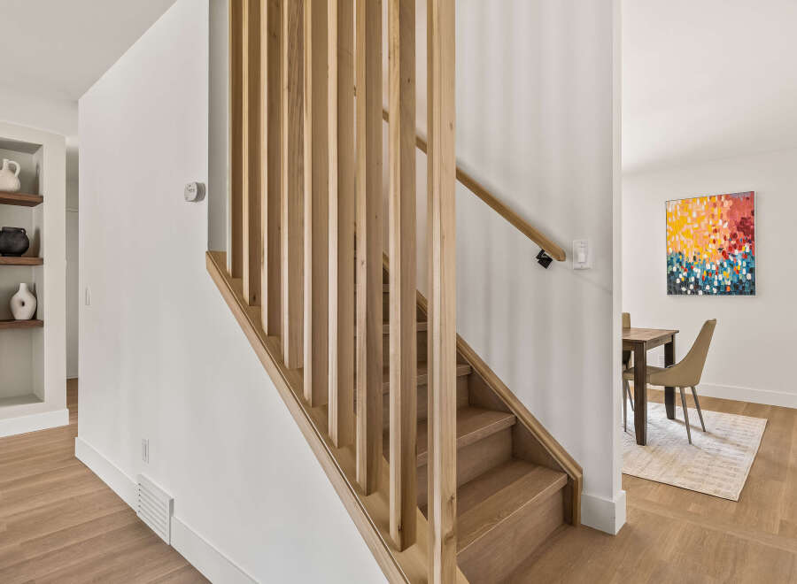 This stunning property boasts a modern staircase with a natural wood design, creating a warm and inviting atmosphere.