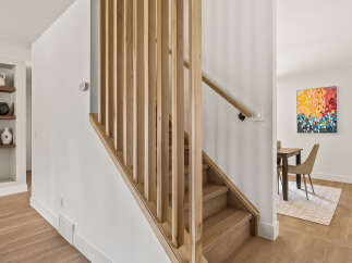 This stunning property boasts a modern staircase with a natural wood design, creating a warm and inviting atmosphere.
