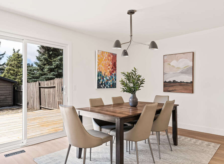 This stunning dining room features a modern aesthetic with a beautiful wooden dining table and stylish chairs.