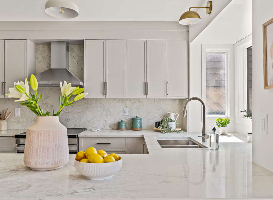 This stunning kitchen boasts a modern design with sleek cabinetry and a beautiful marble countertop.