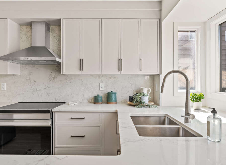 This stunning kitchen boasts modern design with sleek cabinetry and a stainless steel range hood.