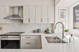This stunning kitchen boasts modern design with sleek cabinetry and a stainless steel range hood.