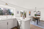 This stunning kitchen boasts a modern design with sleek white cabinetry and a spacious layout.
