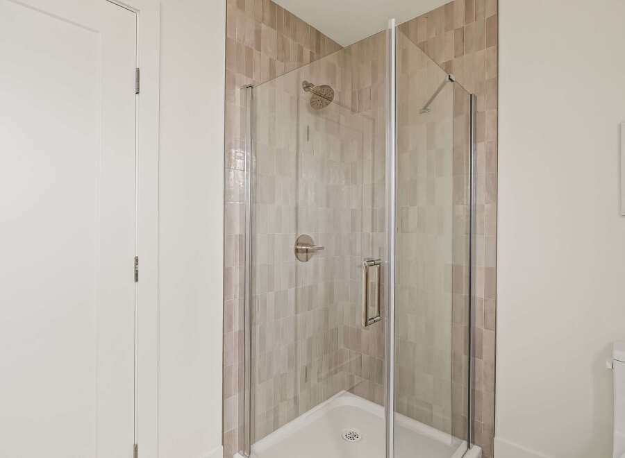 Step into a modern bathroom oasis! This stunning shower features sleek glass doors and elegant tile work, creating a spa-like atmosphere.