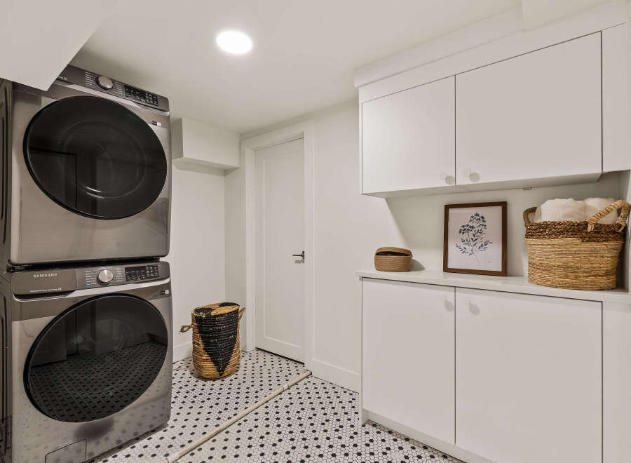 This modern laundry room features a sleek, stacked Samsung washer and dryer, maximizing space and efficiency.