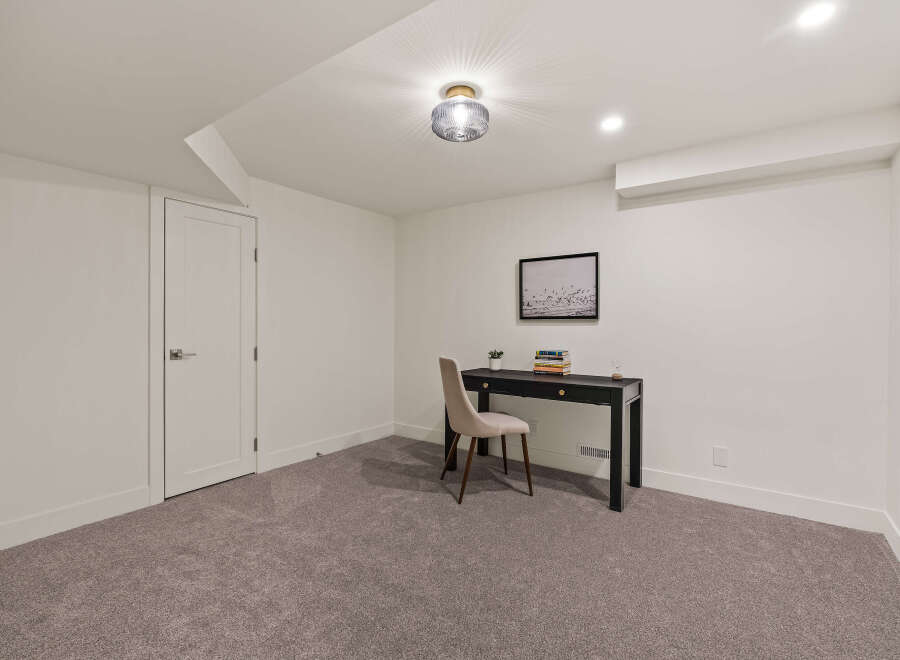 This inviting room features a sleek black desk and a comfortable chair, perfect for a home office or study space.
