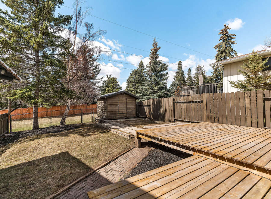 Enjoy outdoor living in this beautiful backyard! This property features a spacious wooden deck, perfect for entertaining or relaxing.