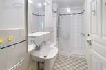 Discover this charming bathroom featuring a modern pedestal sink and a convenient shower area.
