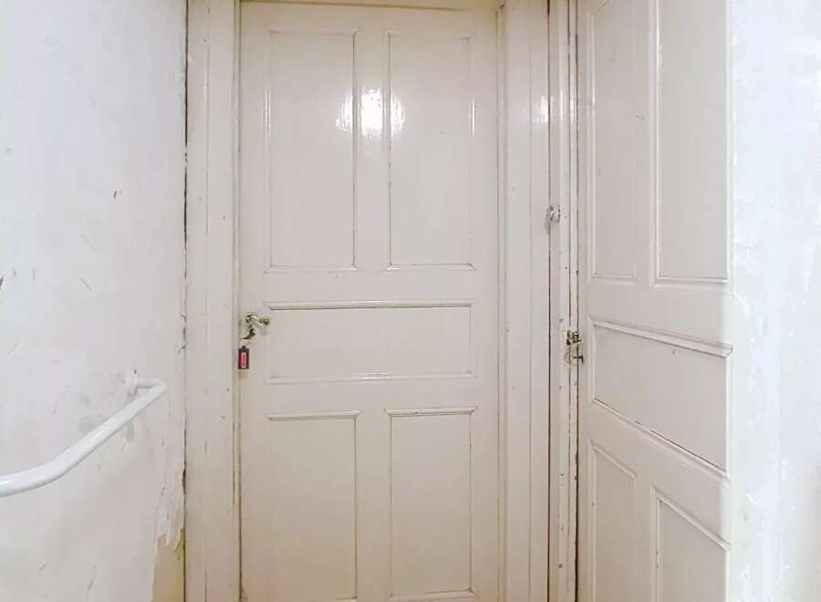 This property features a bright and inviting hallway with two white doors.