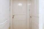 This property features a bright and inviting hallway with two white doors.