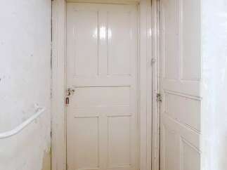 This property features a bright and inviting hallway with two white doors.