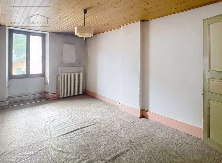 Discover the potential of this charming property! This space features a cozy atmosphere with a wooden ceiling and a large window.