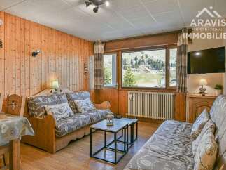 Discover the charm of this cozy property, featuring a warm wooden interior and comfortable seating arrangements.