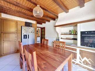 Discover the charm of this inviting kitchen, featuring a warm wooden dining table and chairs, perfect for family gatherings.