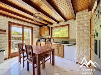 This charming kitchen features a warm, inviting atmosphere with its wooden ceiling beams and cabinetry.